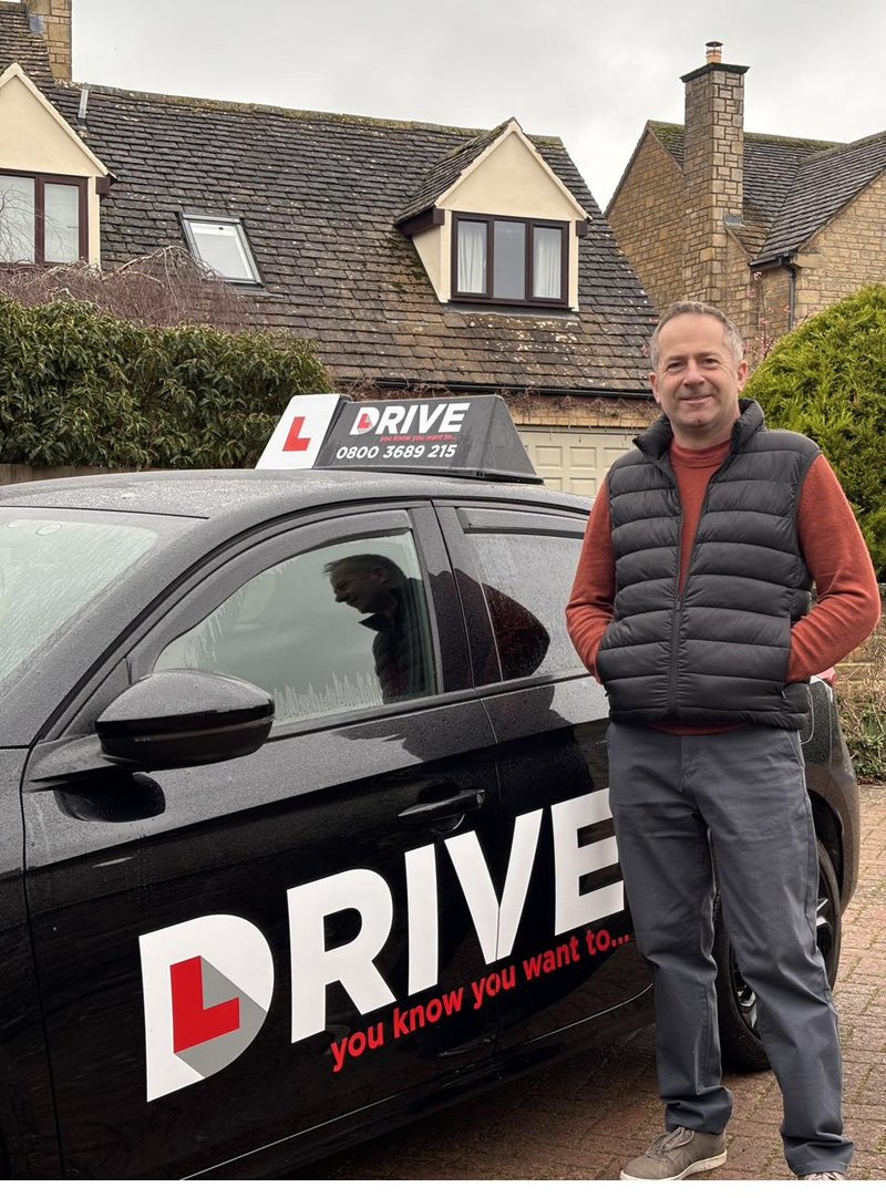 Matt Billings, fully qualified ADI and driving instructor in Cheltenham, standing beside his tuition vehicle